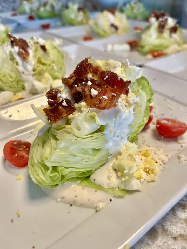 Fresh Wedge Salad featuring bacon, tomatoes, and lettuce on a plate.