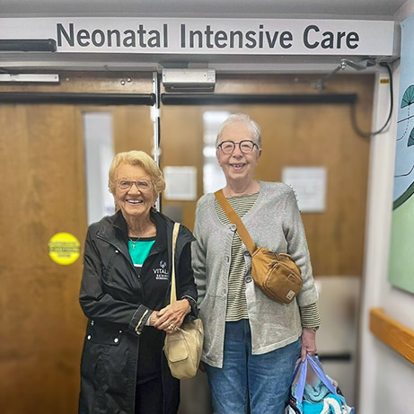 Two senior women from Vitalia Strongsville bring gifts to a local Neonatal Intensive Care Unit.
