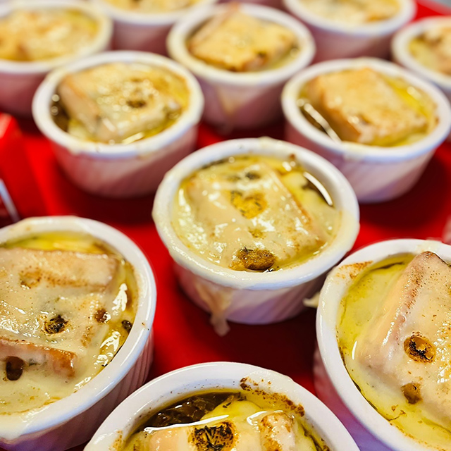 Ramekins full of chef-prepared french onion soup, topped with toasted bread and melted cheese.